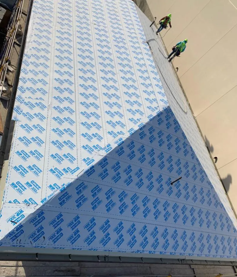 Professional roofers installing underlayment on a metal roof in West Orange